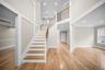 Staircase with ornamental molding, a high ceiling, wood finished floors, and recessed lighting