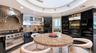 Professional-grade range, custom cabinetry, and kitchen layout leading to a walk-in pantry and laundry room