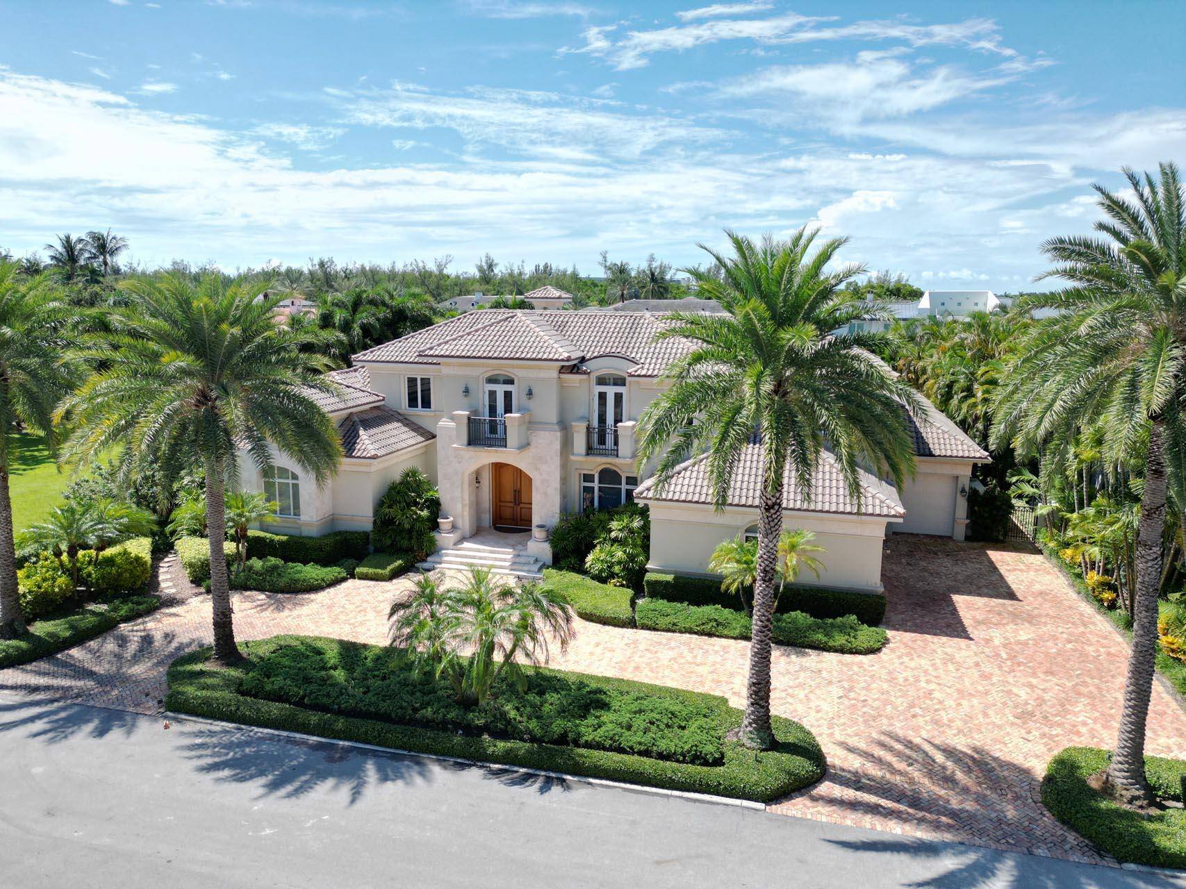Immerse yourself in the unparalleled beauty of this exceptional waterfront estate, meticulously crafted in the prestigious Royal Palm Yacht Country Club.