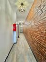 Hall with brick wall and wood finished floors