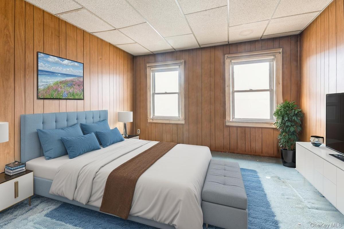 Carpeted bedroom with a drop ceiling and wooden walls