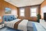 Carpeted bedroom with a drop ceiling and wooden walls