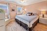 Bedroom with baseboards, light wood-style flooring, freestanding refrigerator, and crown molding