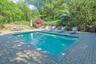 Inspired by the serenity of a Japanese garden, the pool area is surrounded by thoughtfully curated plantings, stonework, and specimen trees.