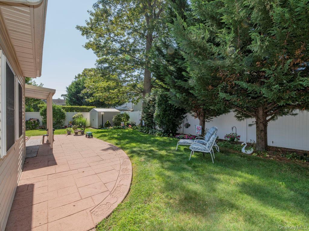 Fenced backyard with a patio area and a shed