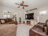 Living area featuring wood-finish flooring, light neutral wall paint, and a classic white staircase with railing
