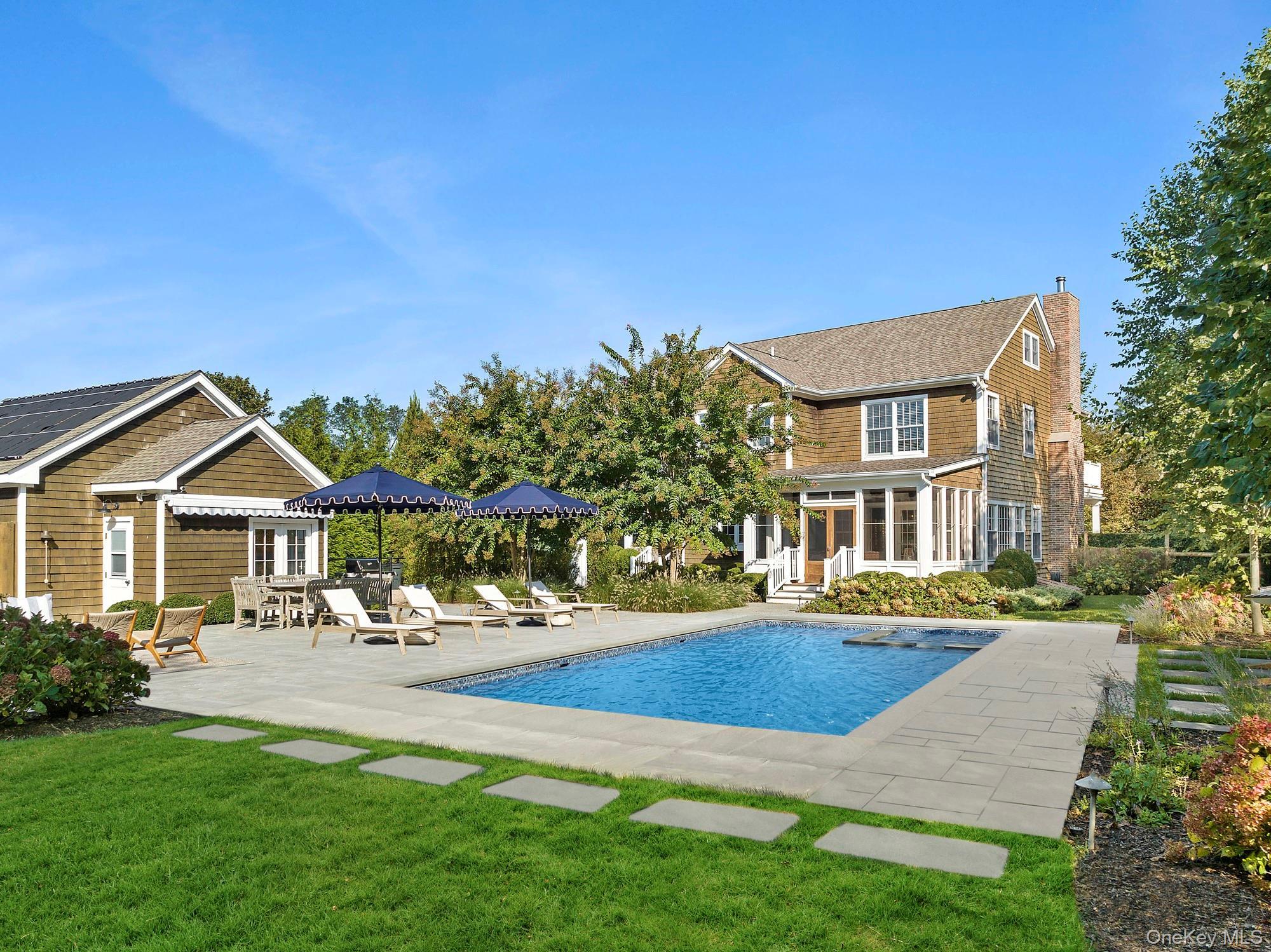 View of swimming pool, house and outbuilding.