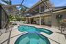 Resort backyard with screened in pool/spa/grill and covered seating