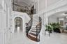 Entryway with arched walkways, light marble finish floors, a decorative wall, stairs, and recessed lighting