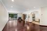 Spacious living area featuring rich wood-finish flooring, recessed lighting, and a stone-surround fireplace