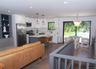 Kitchen featuring stainless steel appliances, dark wood-type flooring, a kitchen island, white cabinets, and backsplash