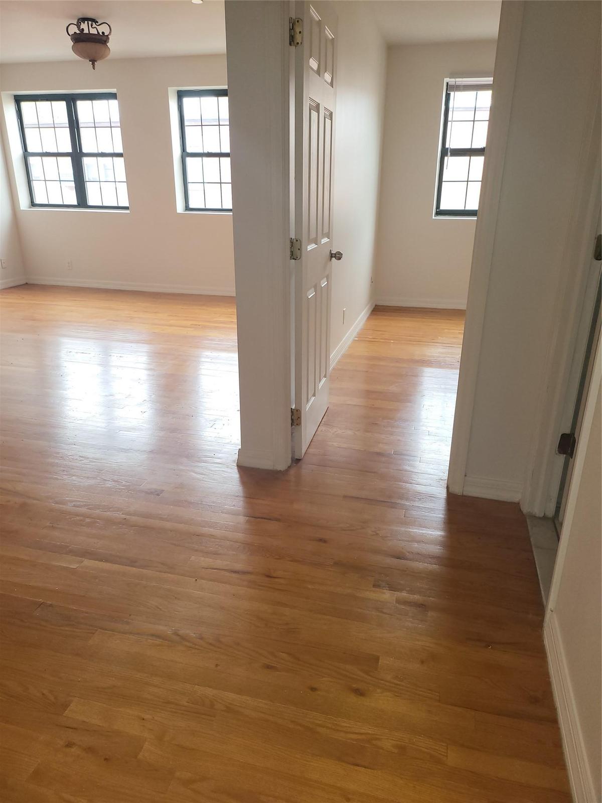Corridor with a wealth of natural light and light hardwood / wood-style flooring