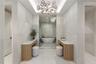 Primary bath with marble floors and walls, wet-room style shower, wet and dry vanities, separate toilet rooms
