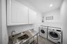 Laundry room featuring wood finish floors, washer and clothes dryer, cabinet space, and recessed lighting