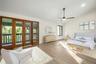 virtually staged primary bedroom with french doors to private balcony