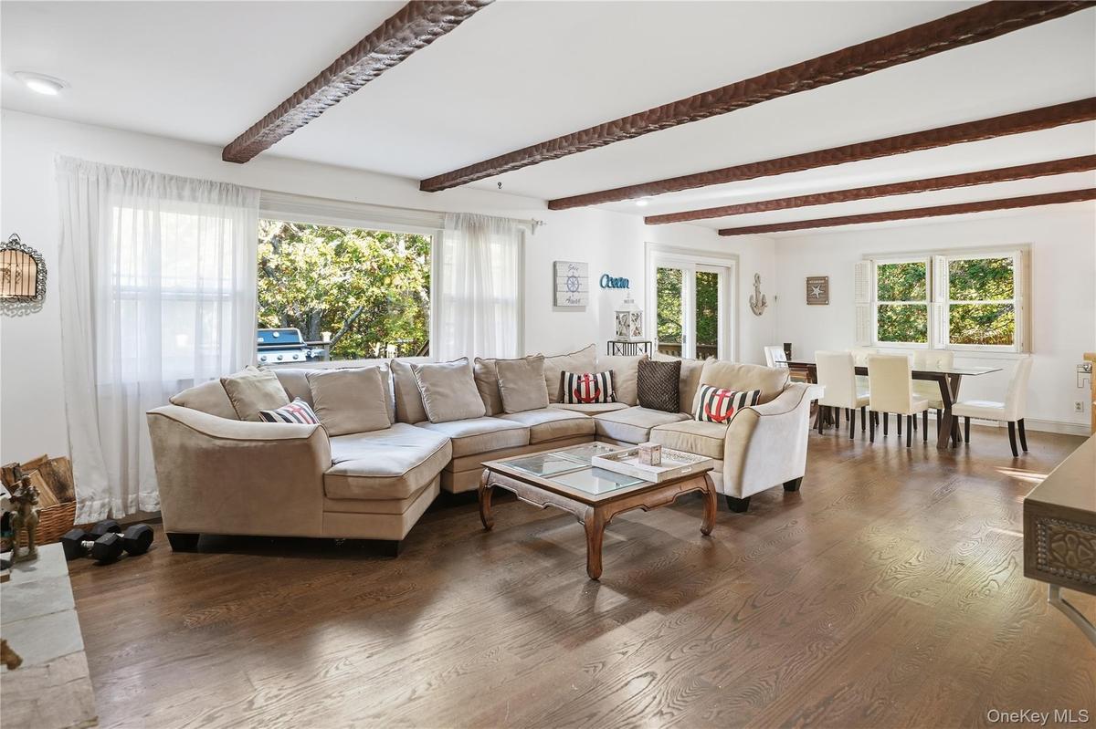 Living room with beamed ceiling and wood finished floors