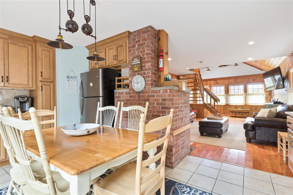 Dining space with wood walls, recessed lighting, light tile patterned floors, and stairs