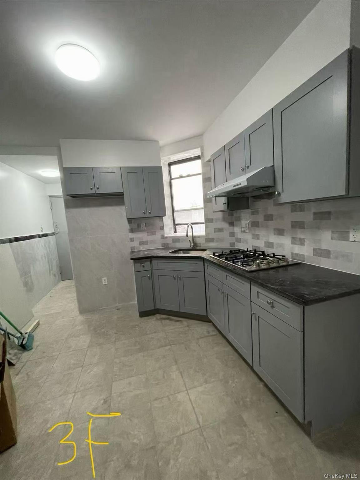 Kitchen featuring gray cabinets, dark countertops, and stainless steel gas cooktop