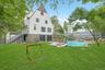 Framed by mature trees and lush greenery, the spacious and usable backyard offers the perfect balance of active play space and resort-inspired outdoor