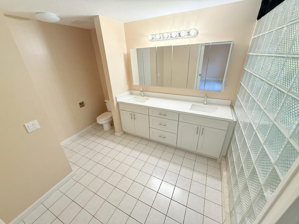 Spacious bathroom featuring a dual vanity with white cabinetry, white countertops, and undermount sinks