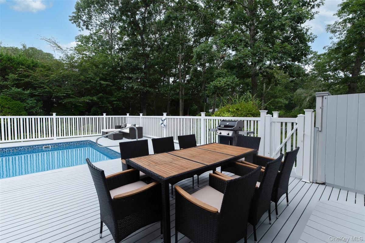View of swimming pool featuring a grill, outdoor dining space, a fenced in pool, and a deck