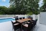 View of swimming pool featuring a grill, outdoor dining space, a fenced in pool, and a deck