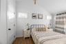 Bedroom with lofted ceiling and dark wood-type flooring