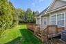 View of green lawn featuring a wooden deck