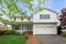 Traditional-style home with french doors, asphalt driveway, an attached garage, and a front lawn