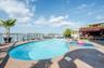 View of pool featuring a water view, a jacuzzi, and a patio area