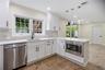 Modern kitchen featuring white cabinetry, stainless steel appliances, a white countertop, and a tiled backsplash