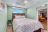 3rd guest bedroom offers a comfortable retreat with a ceiling fan, TV, and built-in closet system for organized storage.