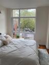 Bedroom with wood finished floors and multiple windows