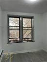 Empty room featuring a baseboard radiator and wood finished floors