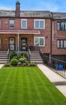 Brick facade home featuring a covered front porch, concrete front steps with metal railings, and a concrete driveway