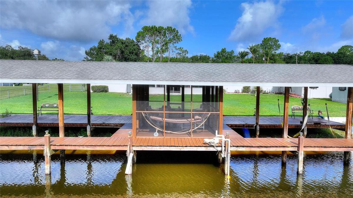HUGE covered boathouse with screened room. One side has a lift.