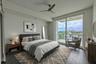 Bedroom 3 is an open and uplifting space, with rich hardwood flooring, crisp white walls, and floor-to-ceiling sliding glass doors that open to a pri