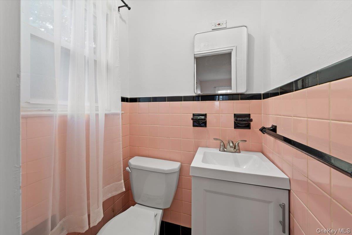 Immaculate half bath in primary bedroom with window, freshly painted.