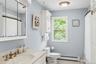 Full bath with a baseboard heating unit, light tile patterned floors, vanity, and curtained shower