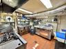 Kitchen featuring stainless steel counters, tile walls, and open shelves