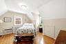 Hardwood flooring and sloped ceilings define this 2nd floor bedroom