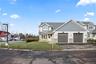 Craftsman inspired home featuring stone siding, asphalt driveway, a front yard, and a garage