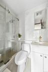Bathroom with vanity, a marble finish shower, light tile patterned floors, and tile walls
