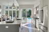 Kitchen with appliances with stainless steel finishes, plenty of natural light, pendant lighting, and an island with sink