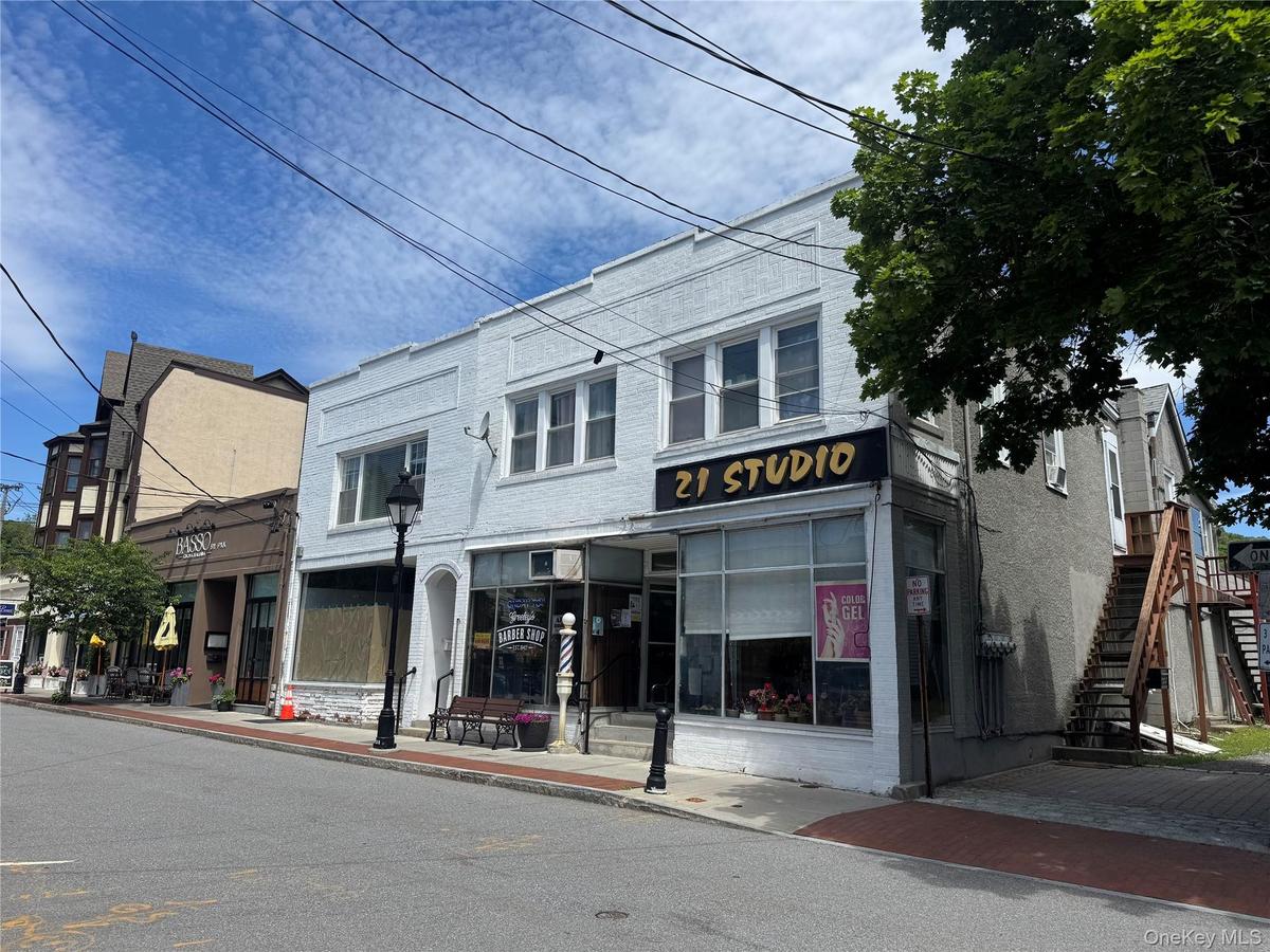 The building features two street-level retail storefronts and a spacious residential apartment above, creating multiple income streams and long-term v