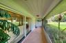 Beautiful porch with vintage broken tile. There are hurricane shutters on the big front windows.