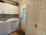 Laundry room with cabinet space, washer and dryer, ornamental molding, and light wood-style floors