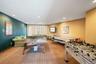 Spacious recreational area featuring recessed ceiling lighting, wall-mounted television, and patterned carpet flooring