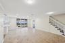 Expansive open-concept room featuring neutral wall tones, large format tile flooring with contrasting accent tiles, and recessed lighting