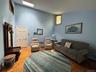 Vaulted ceiling room with natural wood-finish flooring, skylight for abundant light